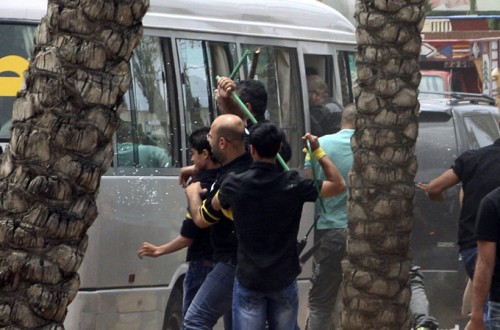 Hezbollah supporters attack a bus carrying anti-Hezbollah protesters in front of the Iranian embassy in Beirut